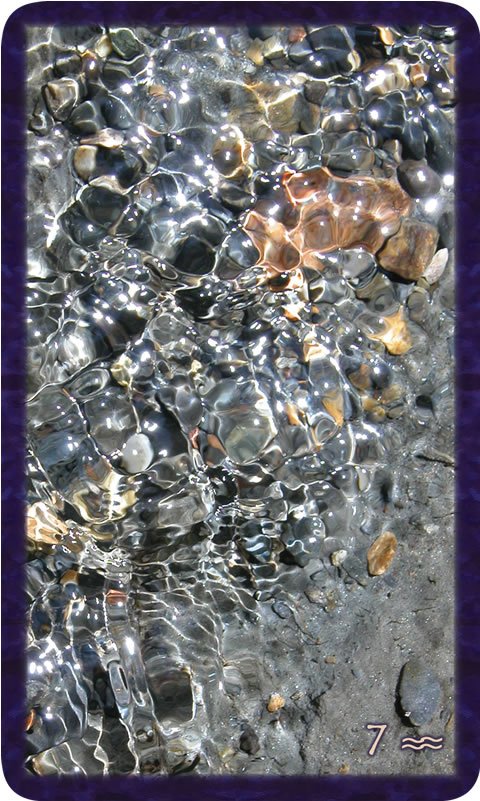 Macro photo of sunshine dappling stones under water. Gratitude Tarot card Seven of Community: let your dreams lead the dance for you and soul-family.